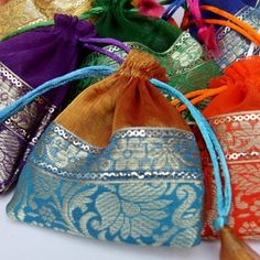 several colorful bags with tassels on them sitting next to each other and one bag is filled with something