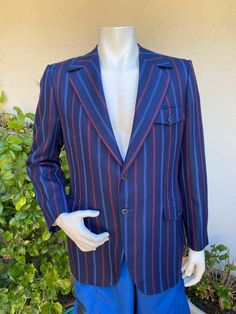 Super cool vintage sport coat!  Dark navy blue with red and blue stripes.  Notched collar with 2-button front and 2-button sleeves.  Center back vent.  Partially lined. Excellent vintage condition.  Amalgamated union clothing label. Label:  Ratner California Clothes Size:  none listed, please check measurements.  Questions are always welcome! Jacket was measured while lying flat across the front seam to seam: underarm to underarm - 22" length from top of shoulder - 31 1/2" shoulder - 18" sleeve from shoulder seam - 24 3/4" Retro Tailored Sport Coat With Notch Lapel, Tailored Retro Sport Coat With Notch Lapel, Retro Single Breasted Sport Coat For Business, Striped Blazer With Pockets And Lapel Collar, Striped Retro Outerwear For Work, Striped Fitted Sport Coat With Long Sleeves, Retro Striped Outerwear For Work, Retro Sport Coat With Welt Pockets And Notch Lapel, Retro Business Blazer