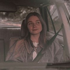 a woman sitting in the back seat of a car