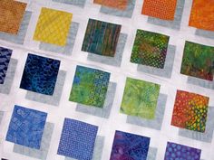 a close up of a quilt with many different colors