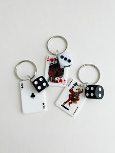 four key chains with playing cards and dices on them