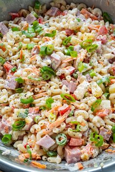 a bowl filled with macaroni salad on top of a wooden table