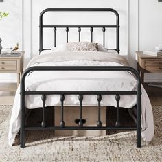 a black metal bed frame in a white bedroom