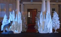 some fake trees are on display in front of a building with columns and pillars that look like they have been made out of snow