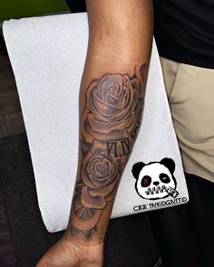 a man's arm with a rose tattoo on it and a panda bear in the background