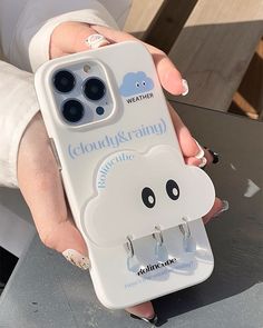 a person holding a cell phone case with a cloud on it