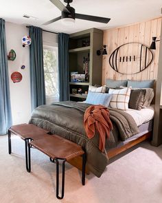 a bed room with a neatly made bed and a ceiling fan