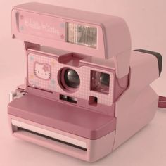 a pink polaroid camera sitting on top of a table