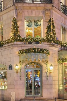 a building that has christmas lights on the windows and decorations all over the front door