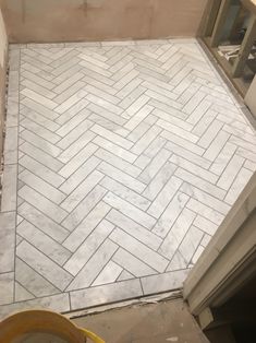 a bathroom floor that is being remodeled with white tile and gray grouting on it