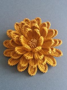 a crocheted flower brooch sitting on top of a table