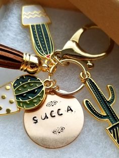 a keychain with a tassel attached to it's side and the words succa on it