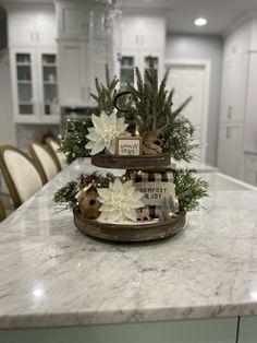 three tiered trays with flowers on top of a marble countertop in a kitchen