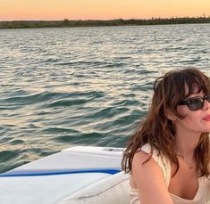 a woman sitting on top of a boat in the water