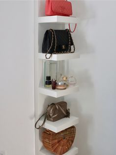 a white shelf with purses, handbags and other items on top of it