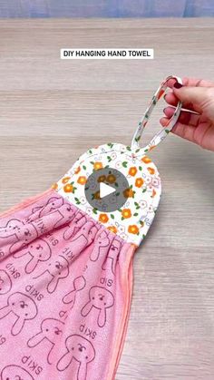 someone is holding a pink towel with an elephant design on it, and the video shows how to sew