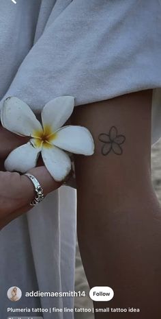 a woman's arm with a flower tattoo on it