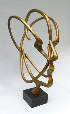 a bronze sculpture on a black stand with white background