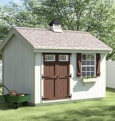 a small shed with a wheelbarrow in the yard