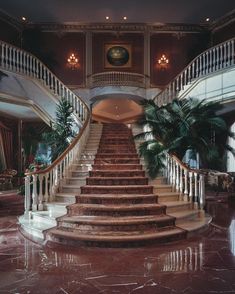 a large staircase in the middle of a building with marble floors and railings on both sides