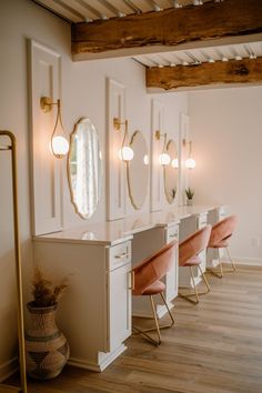 a row of chairs with mirrors on the wall