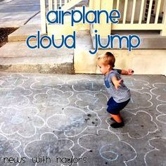 a little boy standing on the sidewalk with chalk writing in front of him that says air plane cloud jump