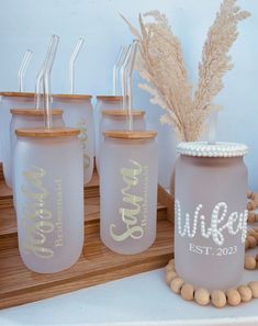 four glass jars with straws in them sitting on a table