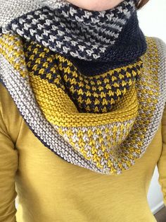 a woman wearing a yellow shirt and black and white knitted cowl scarf over her head