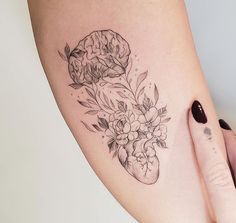 a woman's leg with flowers and a heart tattoo on her left side ribcage