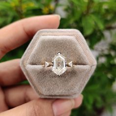 someone is holding an old diamond ring in their hand and it looks like they are going to be sold