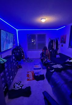 a living room filled with lots of furniture and blue lights on the ceiling above it