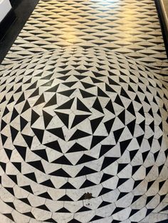 a black and white tiled floor with geometric designs on the top part of it,