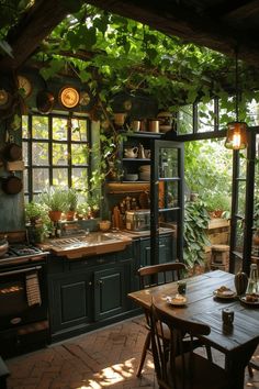 an outdoor kitchen with lots of potted plants on the ceiling and windows over the stove