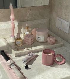 a bathroom counter with cosmetics and other items on it, including a hairdryer