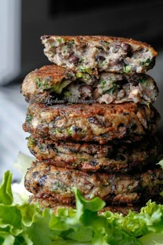 some food is stacked on top of each other in front of lettuce leaves