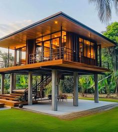 a large house sitting in the middle of a lush green field with stairs leading up to it