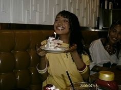 two women sitting at a table eating cake