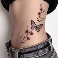 a woman's stomach with a butterfly tattoo on the side and flowers growing out of it