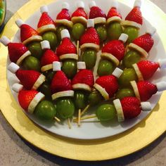 strawberries and green olives are arranged on skewers with marshmallows