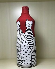 a red vase with black and white cats on it