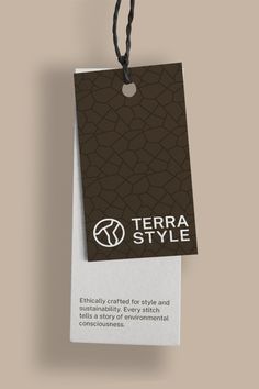 a brown and white tag with the words terra style on it hanging from a black cord