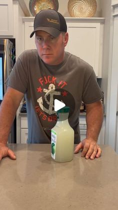 a man sitting at a kitchen counter with a bottle of milk in front of him