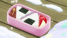 a pink container filled with food on top of a wooden table