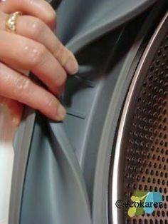 a hand is pressing buttons on the side of a washing machine