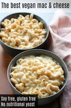 two bowls filled with macaroni and cheese on top of a wooden table