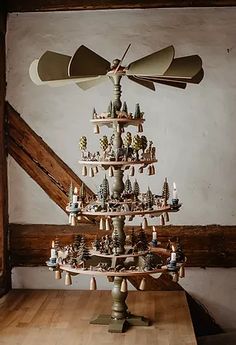 a wooden table topped with a christmas tree made out of wind chimes and candles