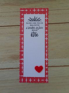 a red and white bookmark with a heart on it