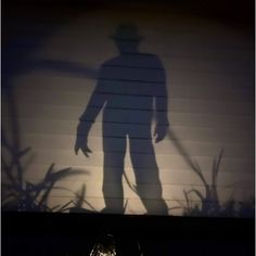 the shadow of a man standing in front of a garage door