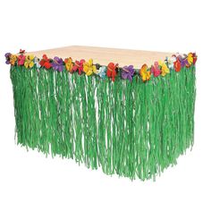 a wooden table topped with grass and flowers