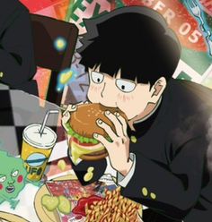 an image of a man eating a hamburger at a table full of food and drinks